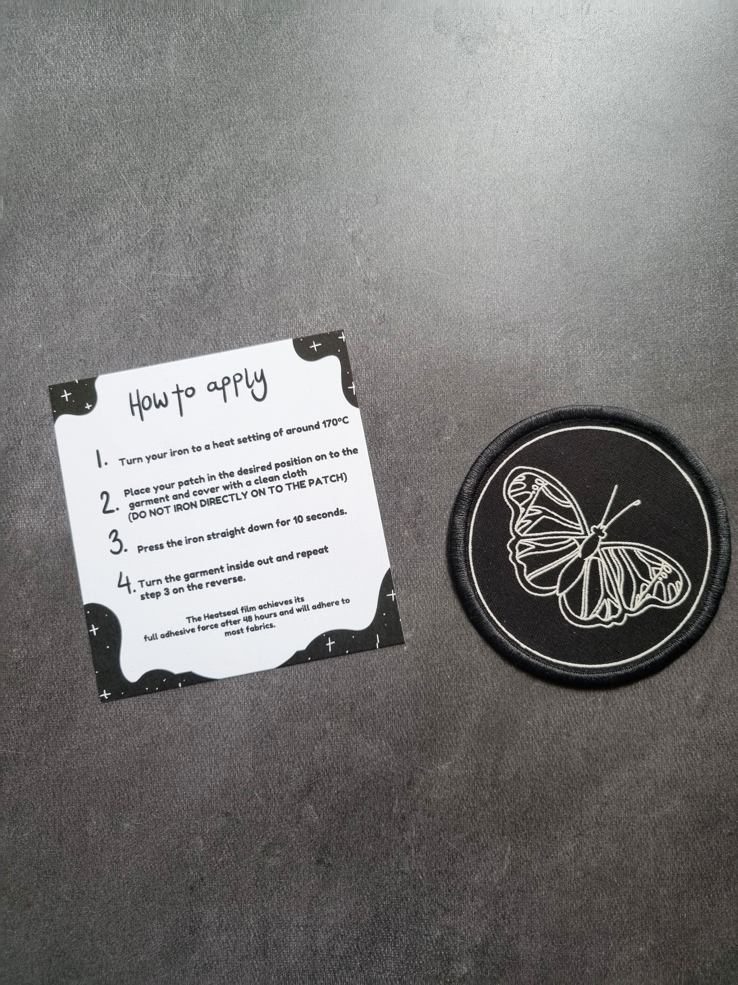 Butterfly Iron-on Patch - EmilsDoodles
On a grey background to the left is an instruction sheet on how to apply the iron on patch, which is on the right.