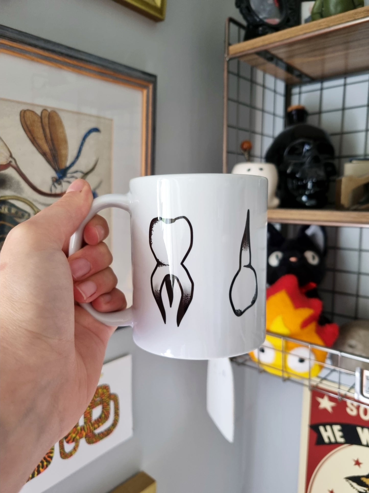 Teeth Teeth Teeth 11oz Mug - EmilsDoodles
A hand holding a mug. The teeth design on this side is also a molar and a canine tooth.