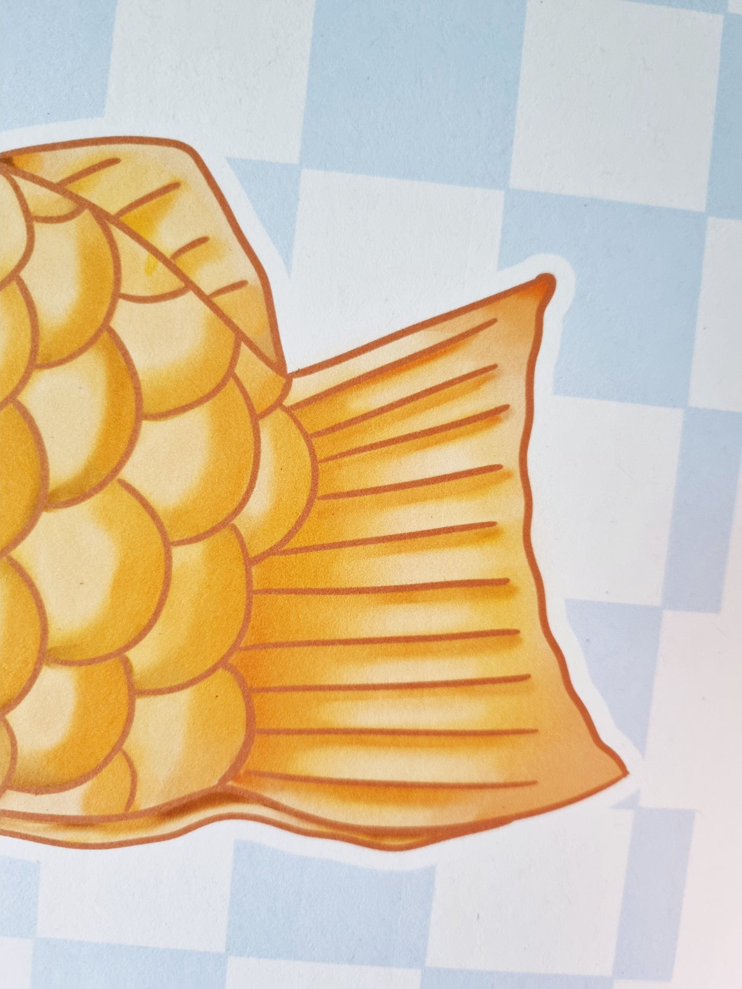 A close up of the tail of the taiyaki. On the tail are lines to represent ridges of the pastry.