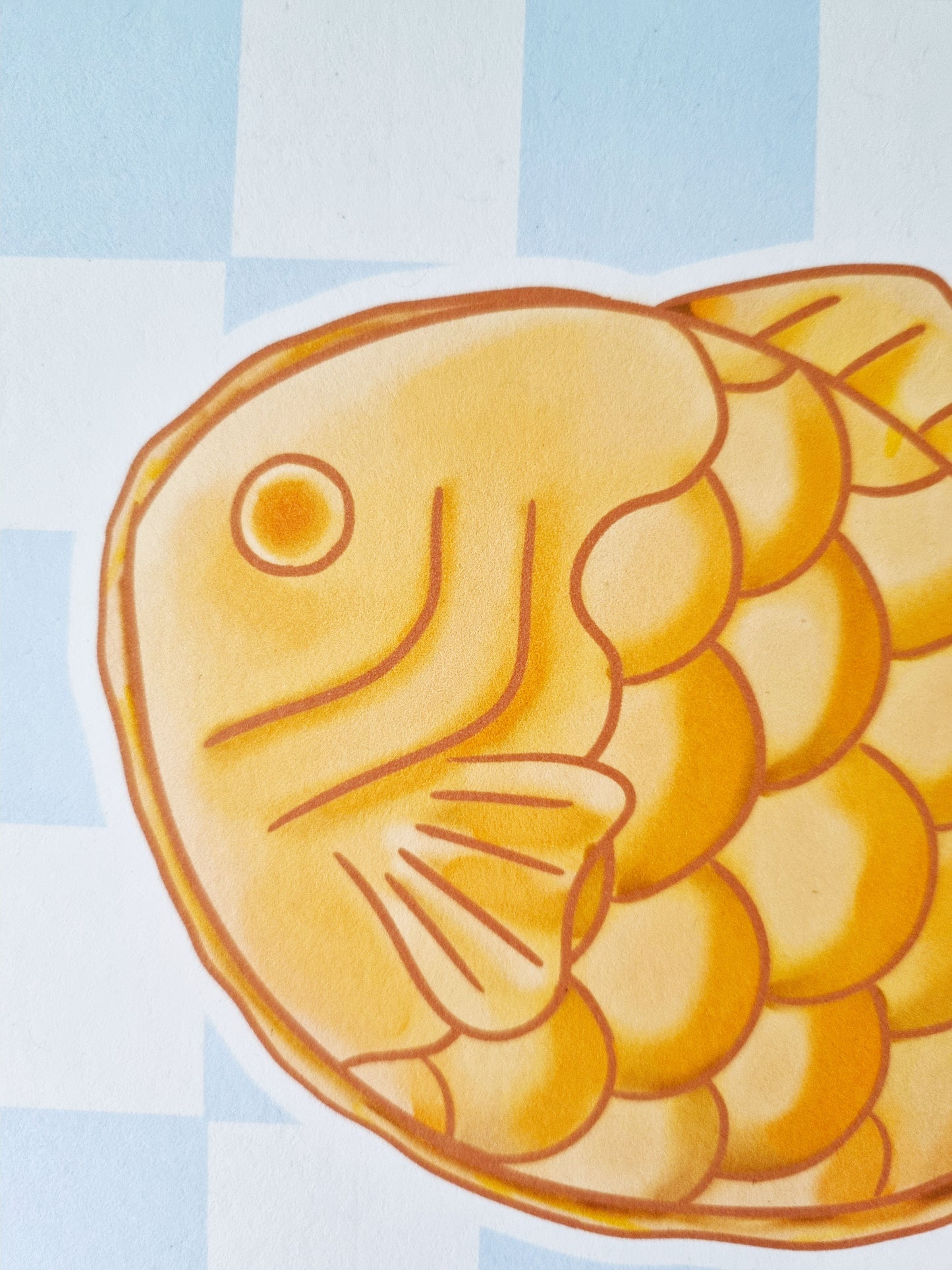 A close up of the pastries face. On top of a blue checked background. The drawings lines are a golden brown colour.