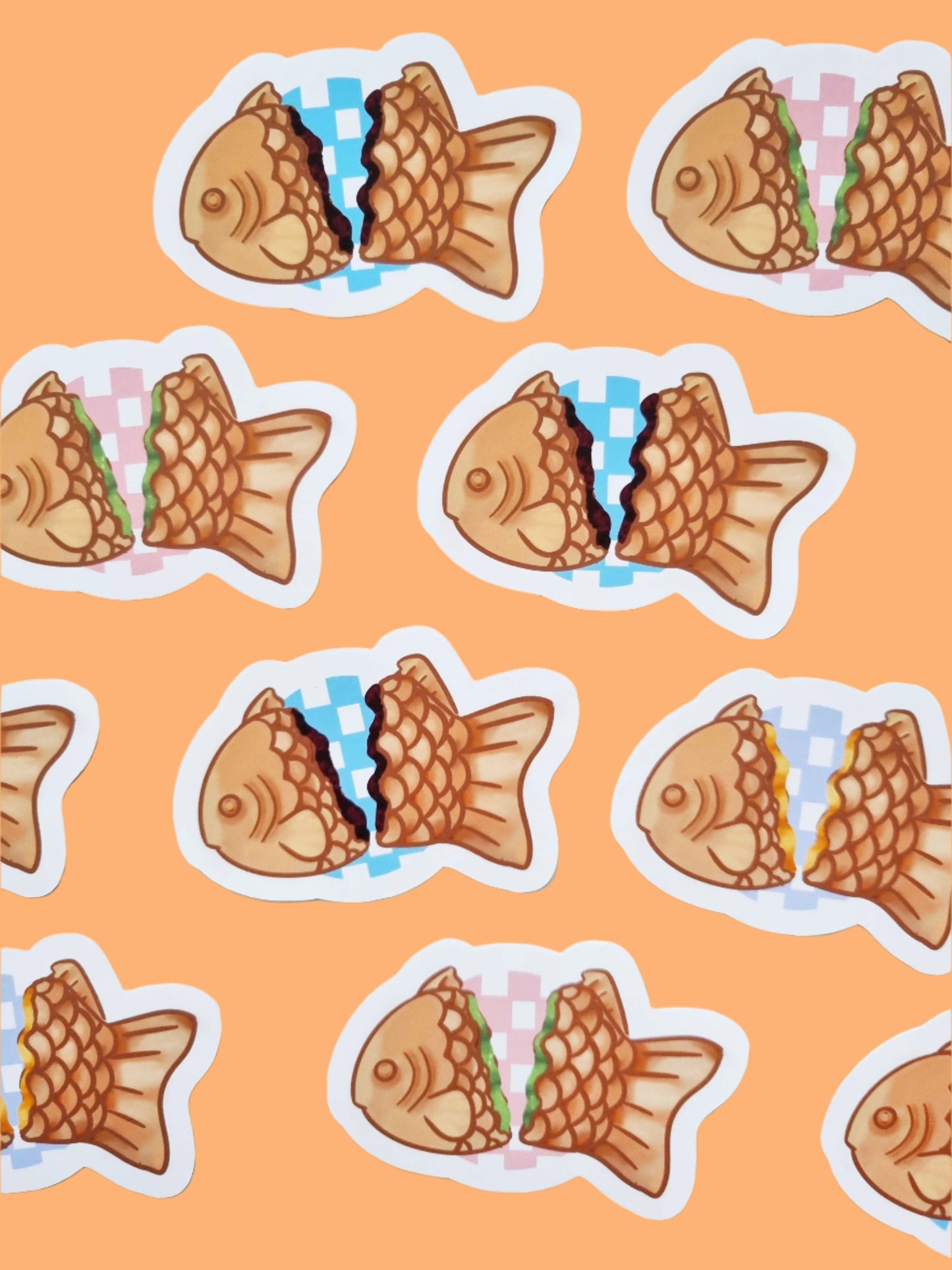 On an orange background has 10 stickers. The stickers are of a Japanese desert called Taiyaki. Each sticker has a different inside colour representing different fillings. They have different coloured checked backgrounds between the two sides.